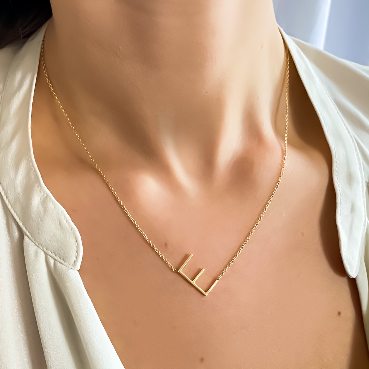Wearing the gold sideways letter E necklace from Alexandra Marks Jewelry