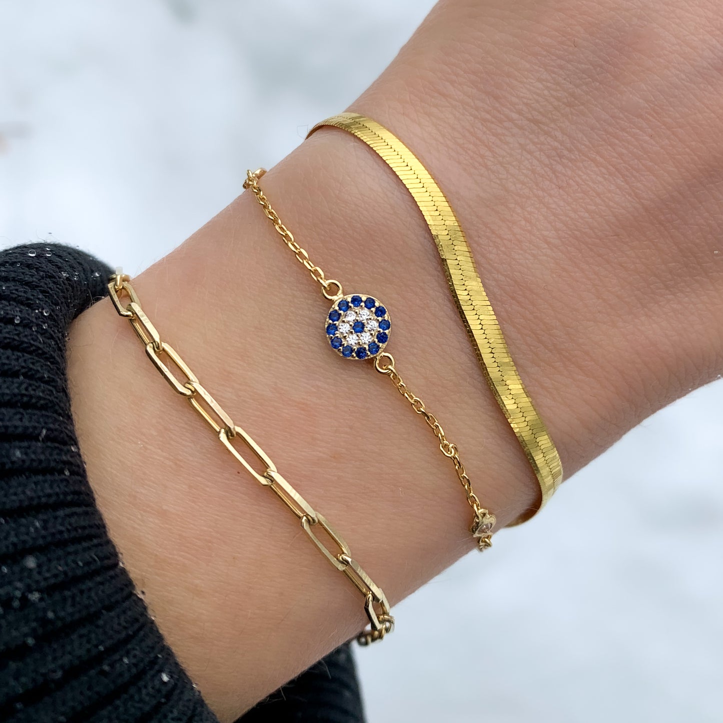 Alkexandra wearing the gold evil eye bracelet