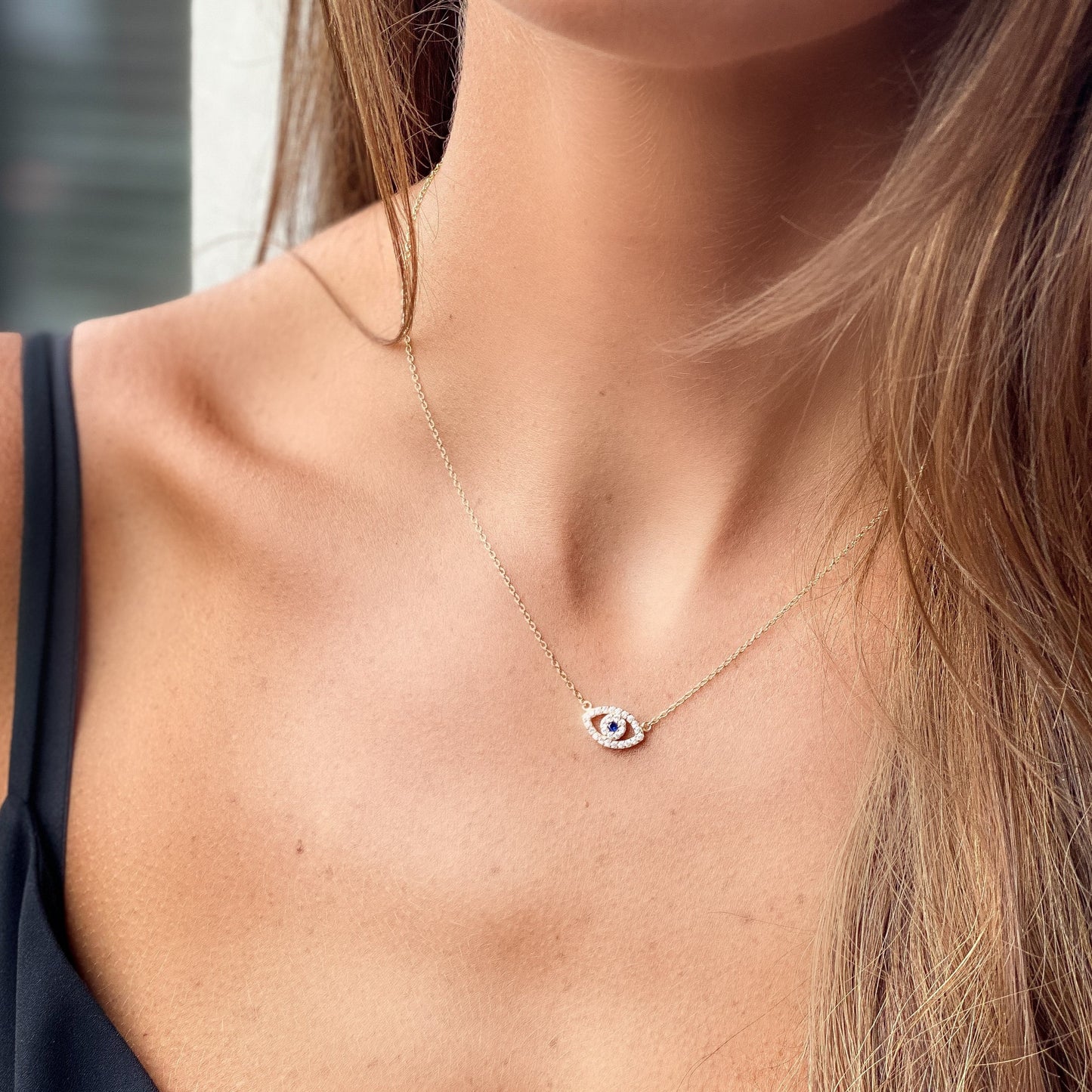 Our classic gold evil eye cz necklace worn by a model