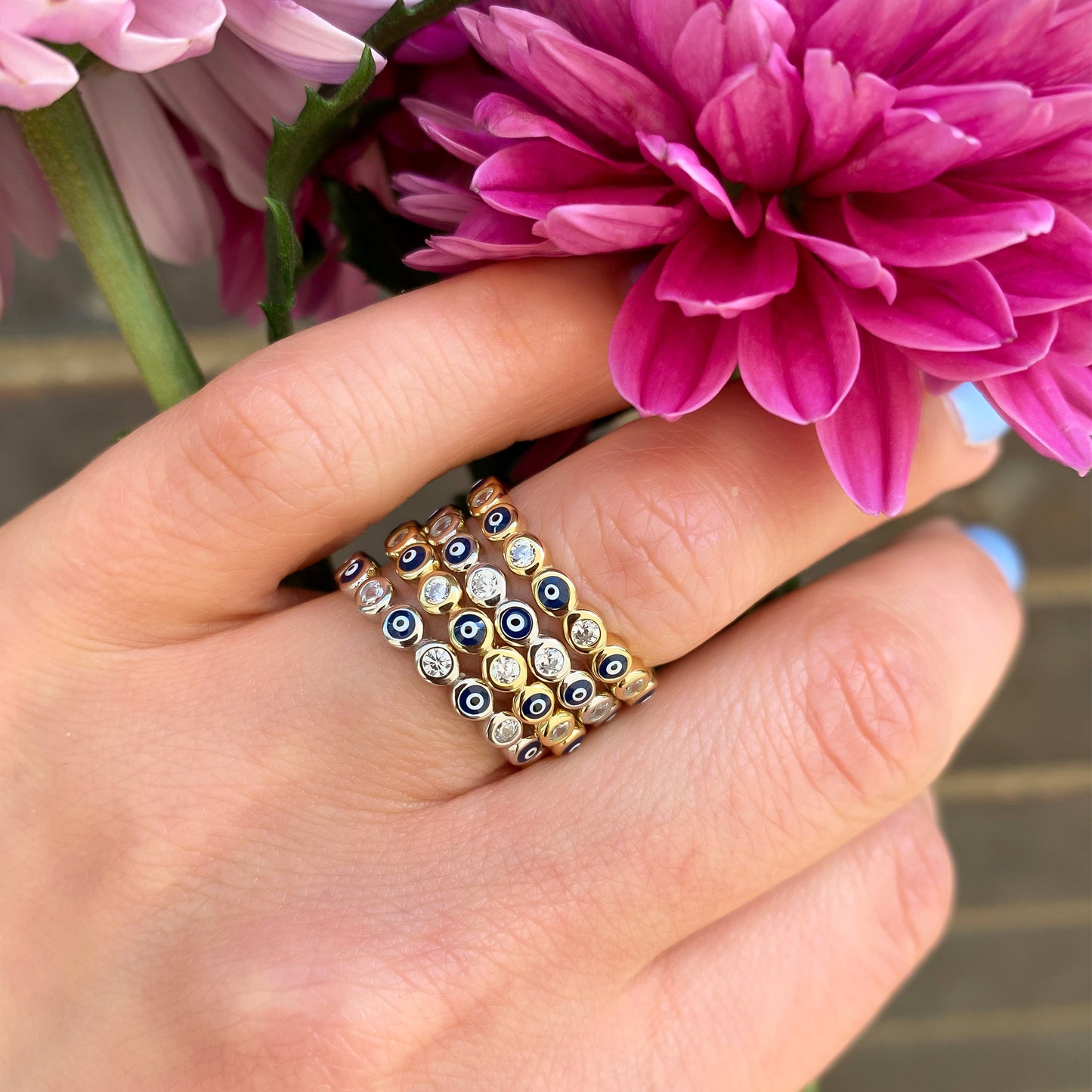 Evil Eye eternity band in silver and gold being stacked on a finger at Alexandra Marks Jewelry