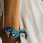 Holding three different Evil Eye statement necklaces in gold from Alexandra Marks Jewelry