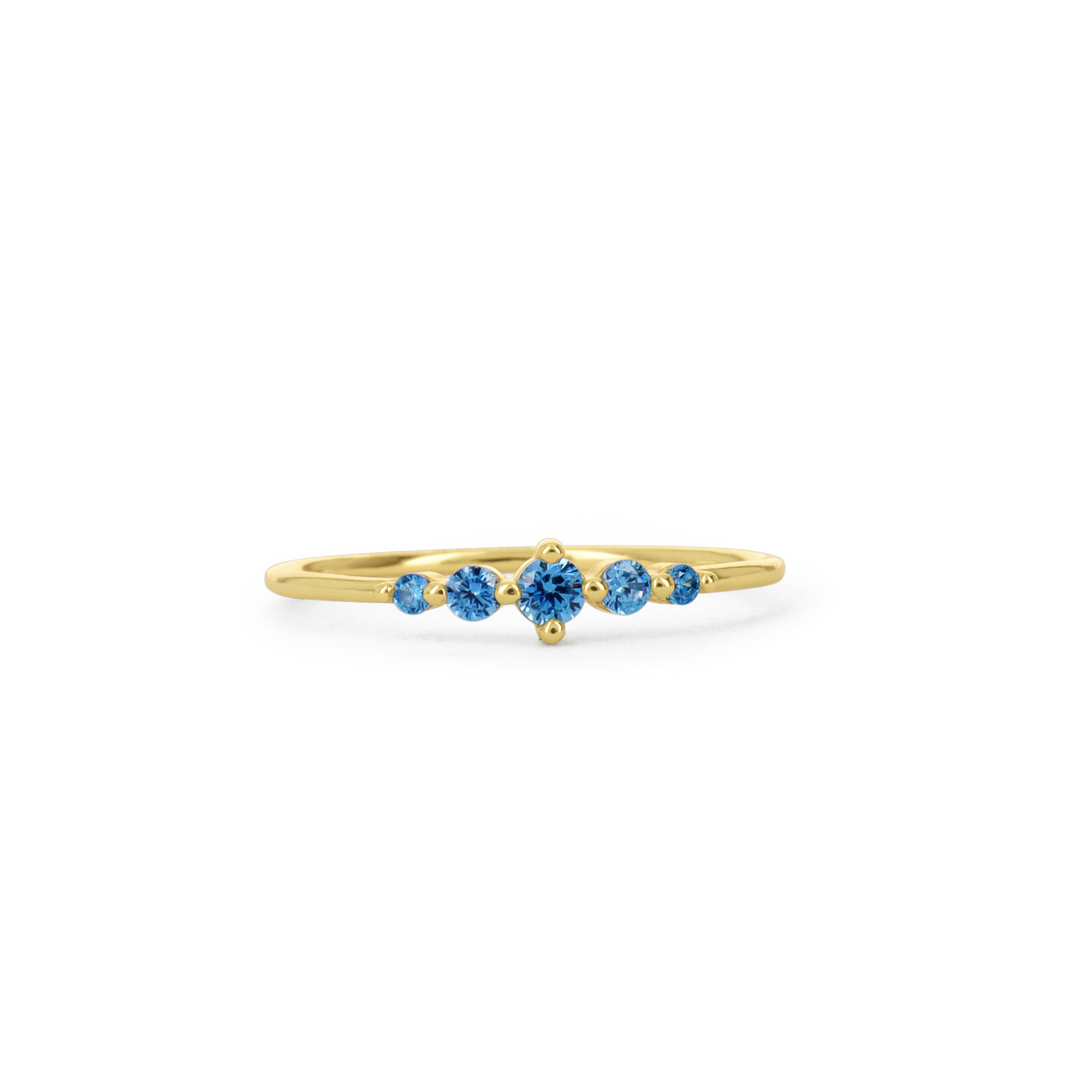 A delicate yellow gold ring featuring a row of five round-cut blue gemstones, set against a plain white background.
