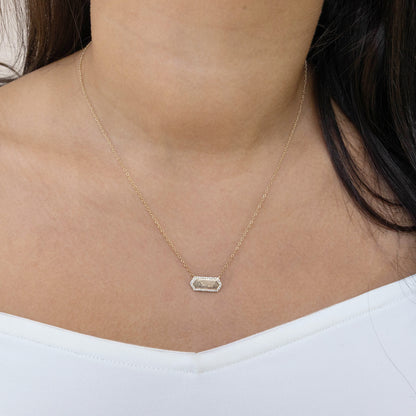 Hexagon gold bar necklace on a person