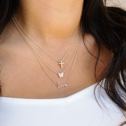 Diamond cross, butterfly and love script necklace in gold from Alexandra Marks Jewelry