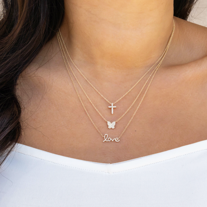 Necklace with 'love' pendant worn by a person on a white background