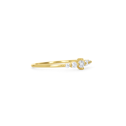 A delicate yellow gold ring featuring three small round-cut clear gemstones in a row, set against a plain white background.