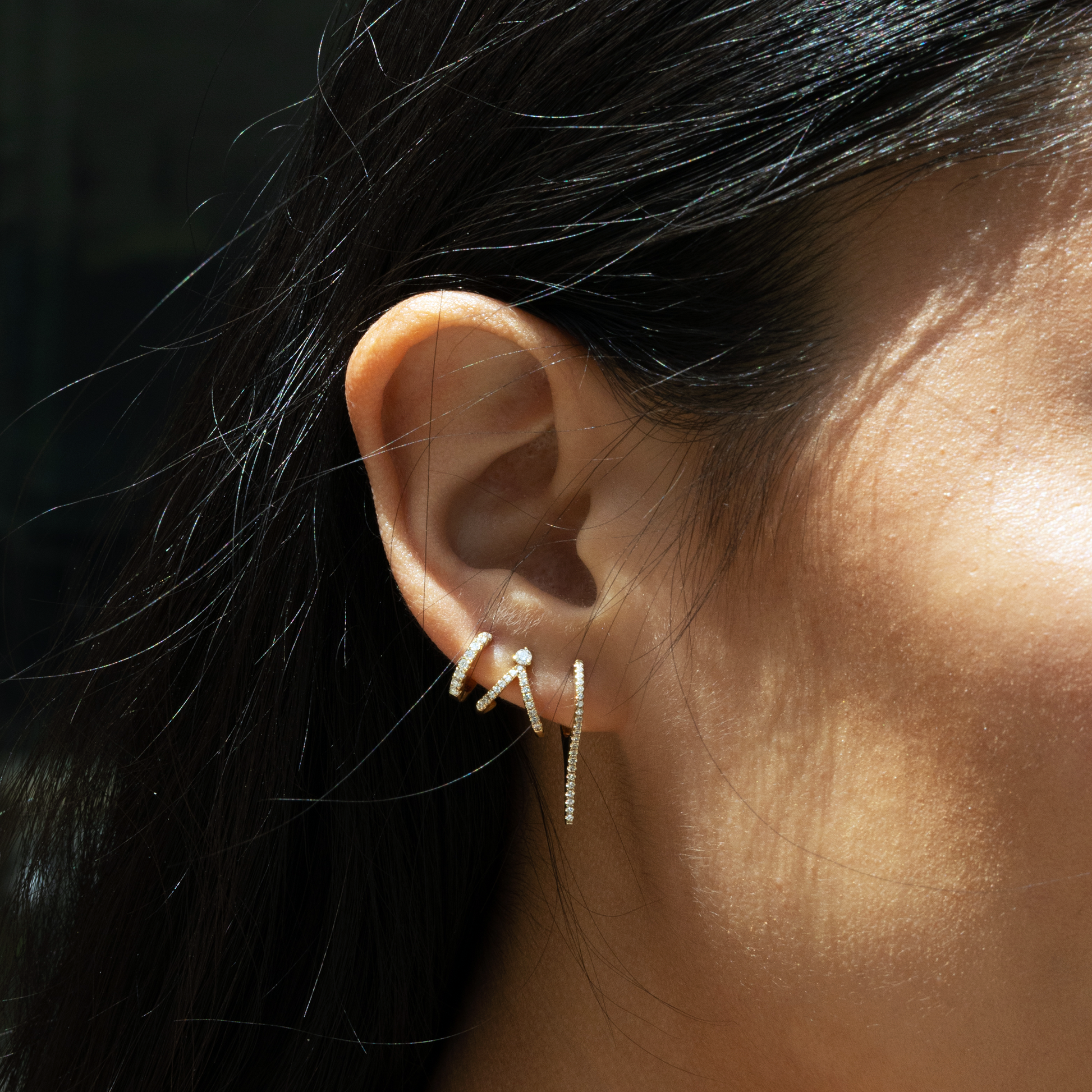Dainty diamond earring stack in 14kt yellow gold featuring a bar drop hoop, tiny huggie earring and a spilt v stud. 