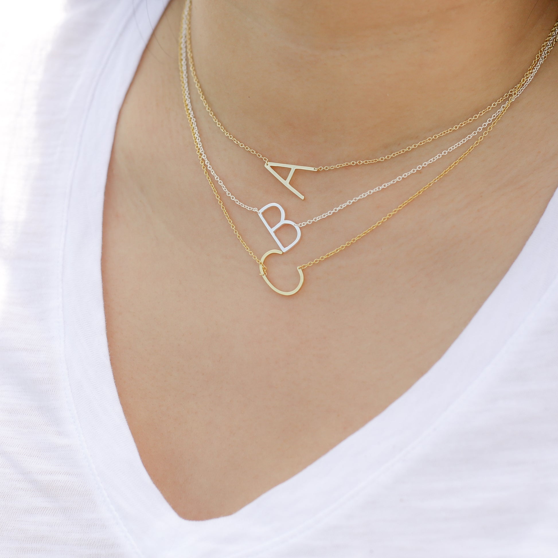 Stacking our gold and sterling silver sideways initial necklaces