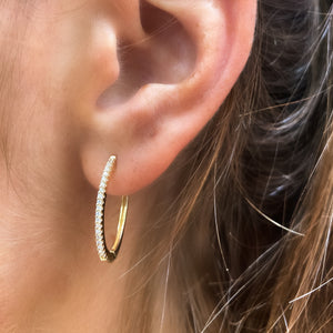 Frontal view of our 14kt Yellow Gold Oval Diamond Hoop Earrings in a ear