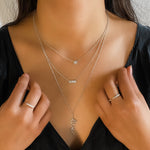Wearing the petite diamond disc necklace layered with other white gold diamond necklaces from Alexandra marks Jewelry