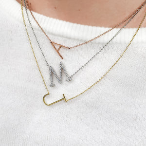 Wearing our Alexandra Marks sideways initial necklaces in silver, gold and rose gold