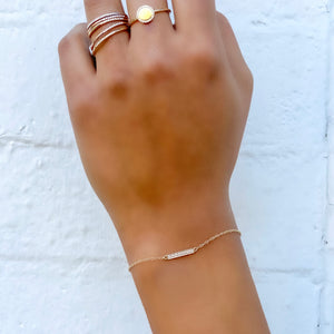 Wearing the 14kt yellow gold dainty diamond bar bracelet