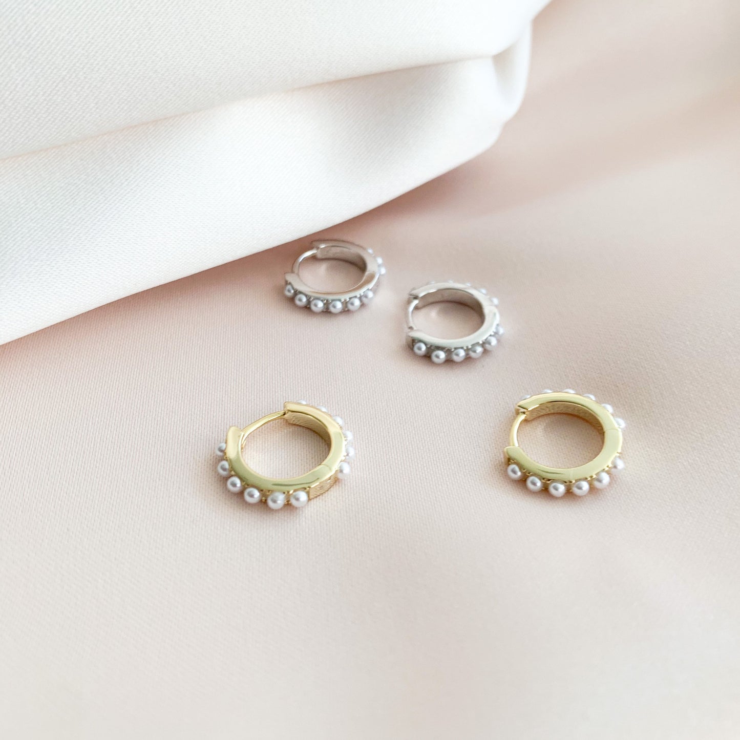 The gold and silver pearl huggie hoops earrings from Alexandra Marks Jewelry