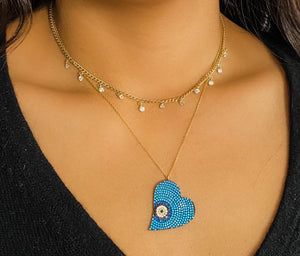 Alexandra Marks | Wearing our sideways blue and turquoise evil eye heart necklace 