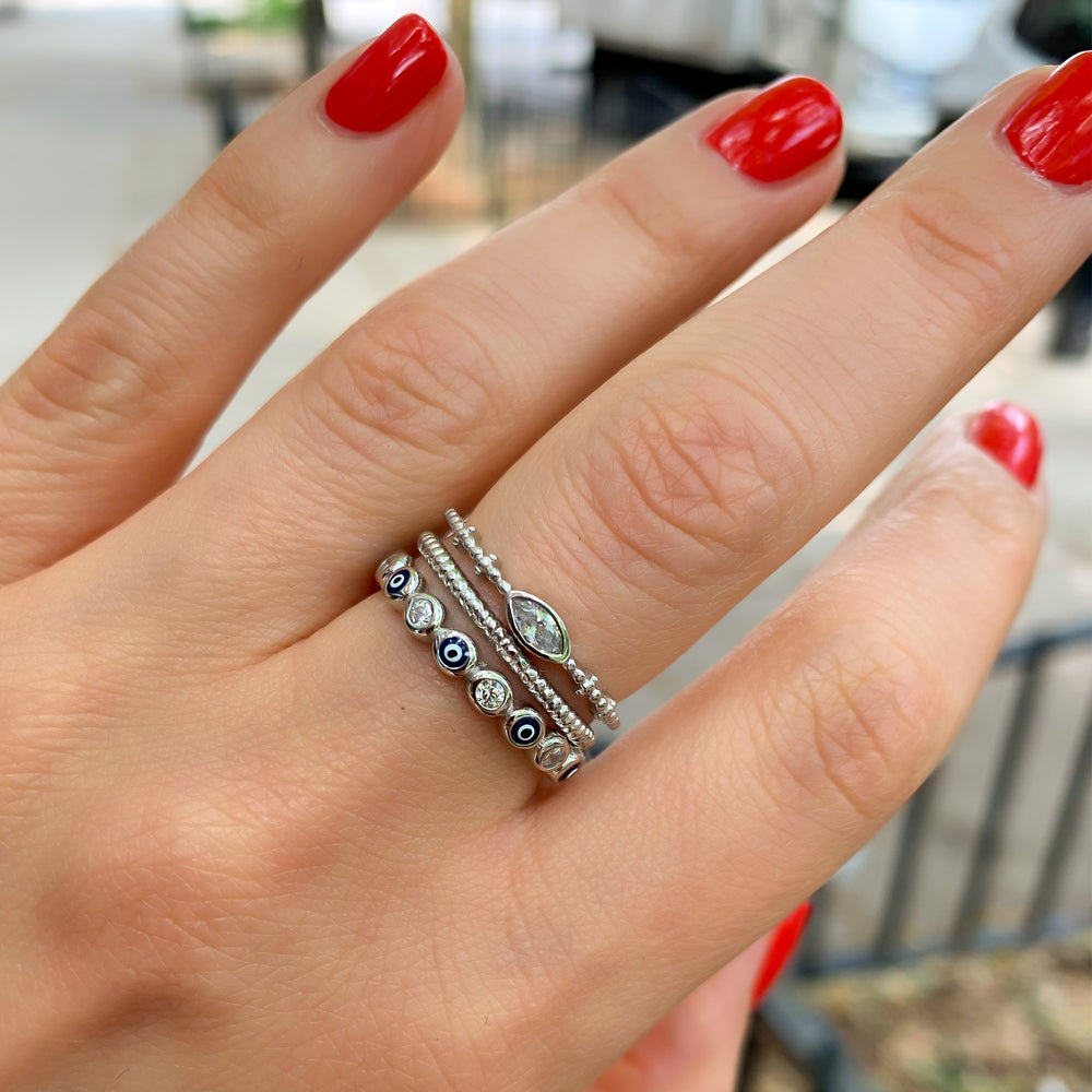 Stackin g the silver and navy blue evil eye eternity band with two other silver rings from Alexandra Marks Jewelry